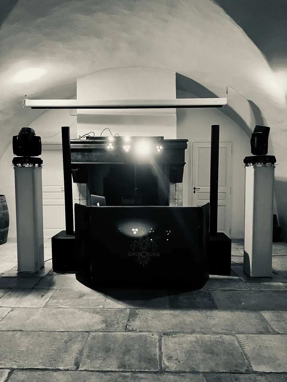 Régie DJ noire avec sonorisation et éclairages sous une voûte